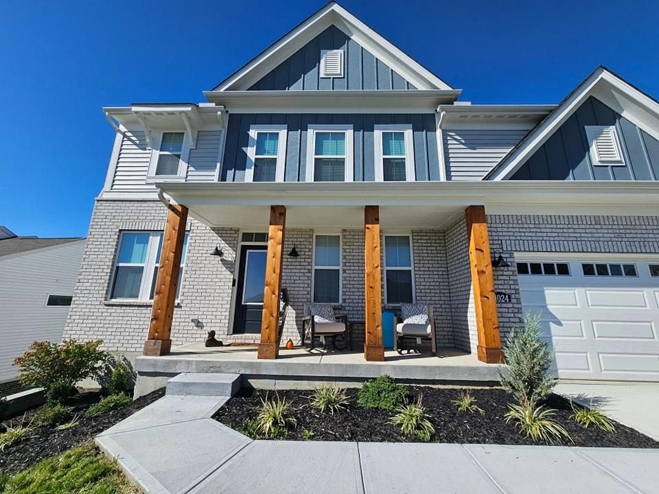 Craftsman style home with freshly painted blue siding and stained wood porch columns