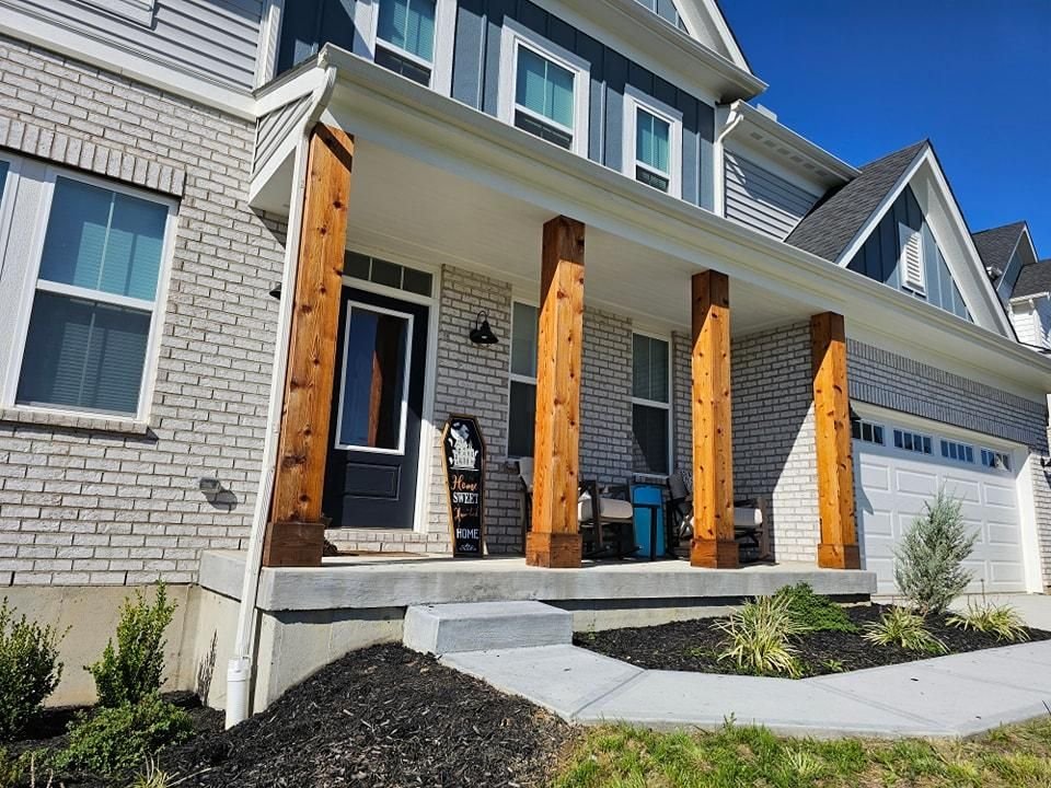 Front porch with newly finished wood columns and painted siding