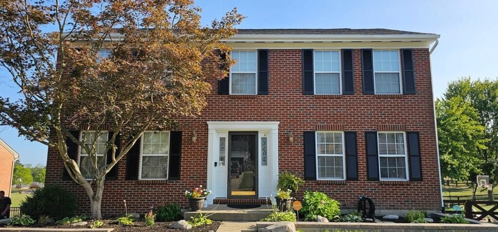 Brick home with freshly painted exterior trim and black shutters