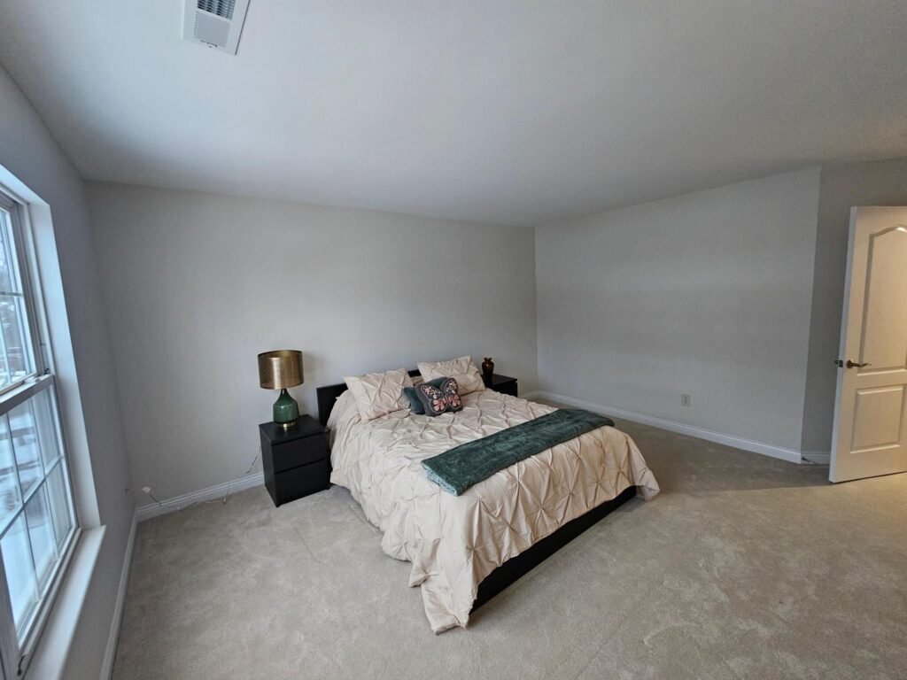 Bedroom with neutral painted walls and crisp ceiling line