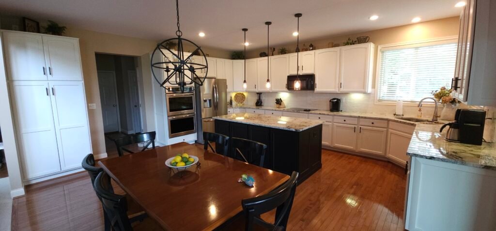 Refinished white kitchen cabinets and a dark island in a Florence, Kentucky home.