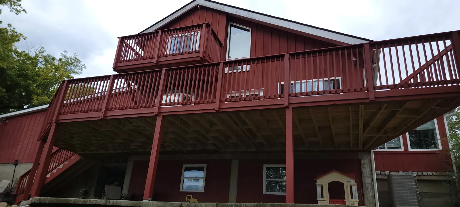 Wide view of the red deck, exterior stairs and railing sections in Alexandria, Kentucky.