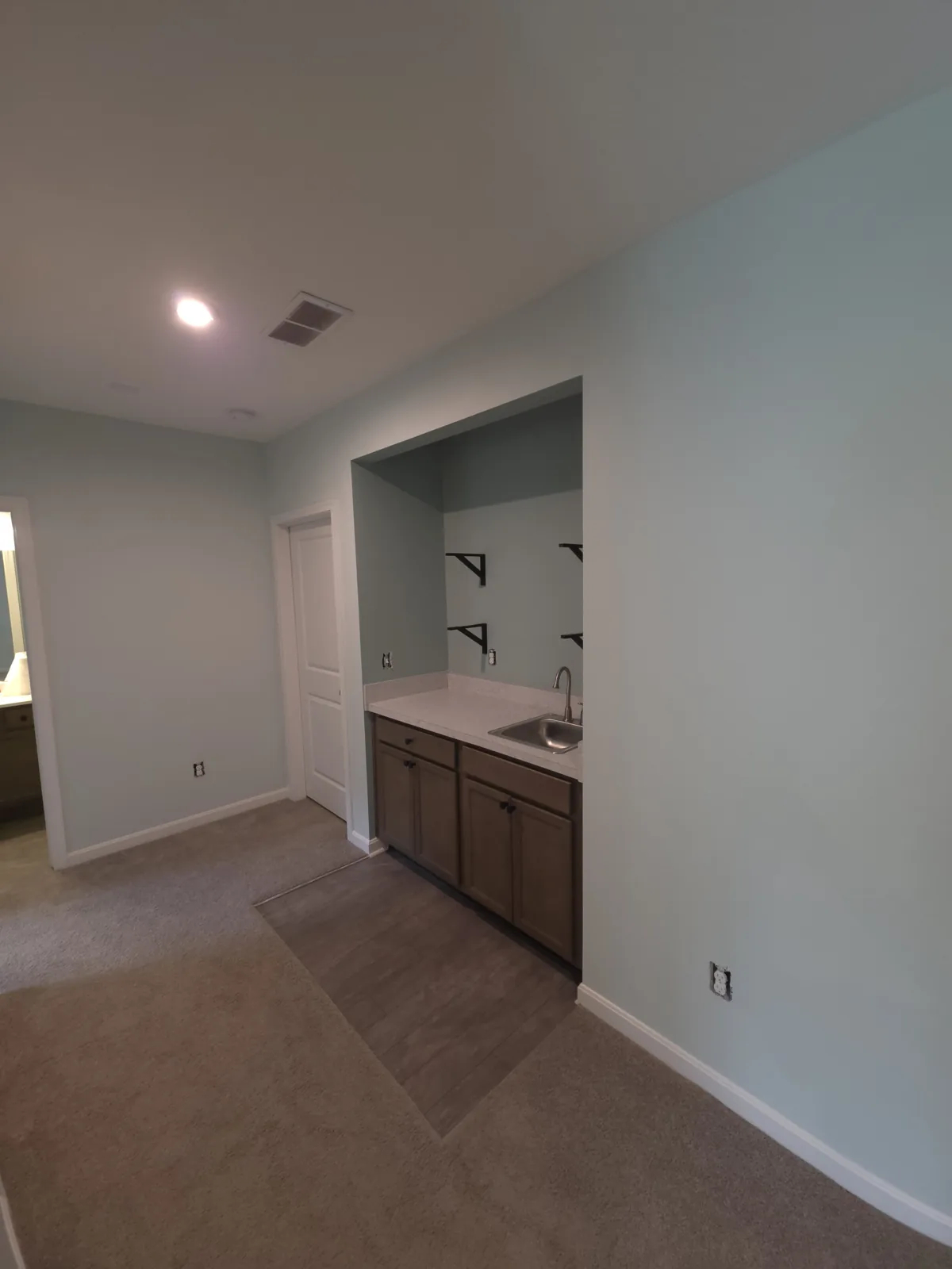 Pale gray interior walls and a recessed kitchenette in Alexandria, Kentucky.