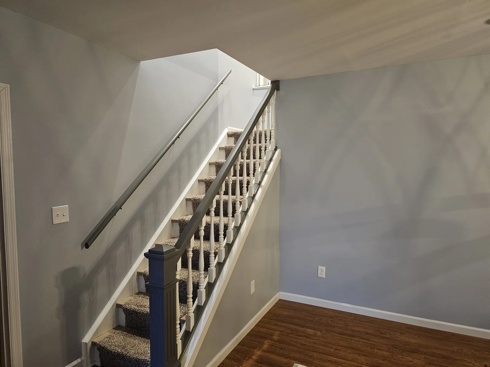 Completed Augusta interior project with gray stairwell walls, white balusters and a dark handrail.