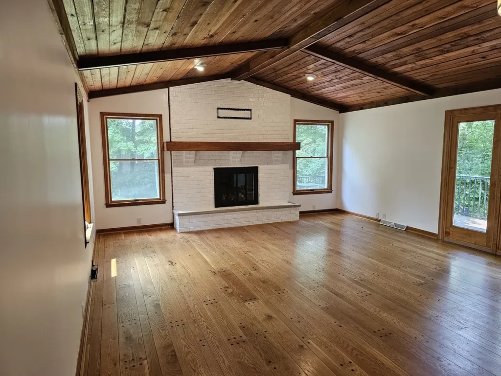 Fort Thomas interior with white walls, a light-colored brick fireplace and a wood ceiling.