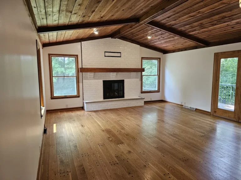Fort Thomas interior with white walls, a light-colored brick fireplace and a wood ceiling.