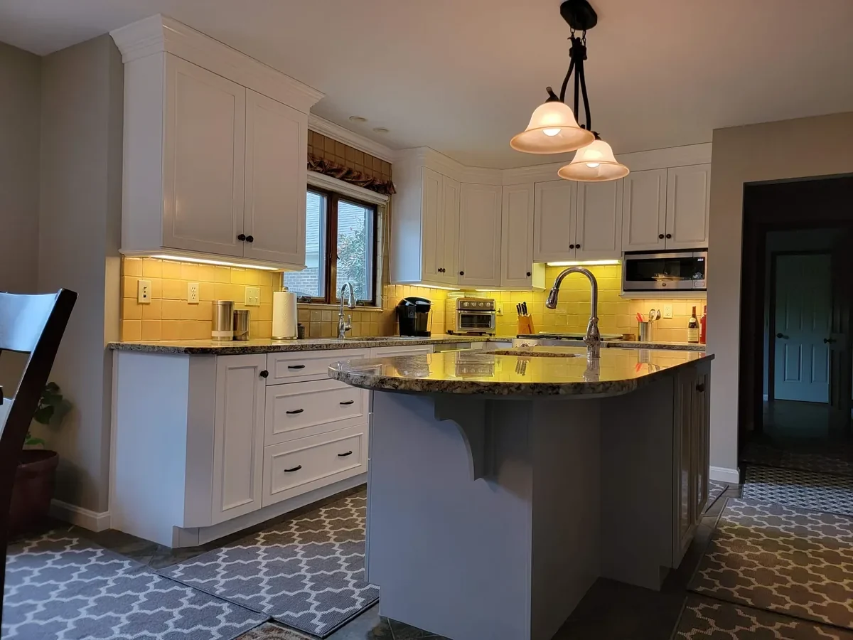 White kitchen cabinets and gray island in Hebron, Kentucky.
